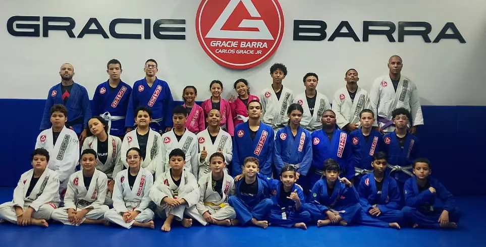 Turma de crianças e adolescentes reunida no tatame